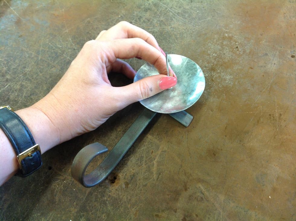 Line up the holes between the metal dish and the two pieces of flat bar, then put a pop rivet in the holes