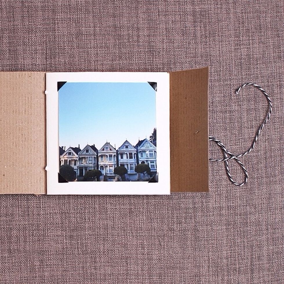 Line up the inside pages with the cardboard paper. Use a needle or something sharp to make 2 holes in the center of inside pages and the cardboard paper. Take the twine to tie it all together.