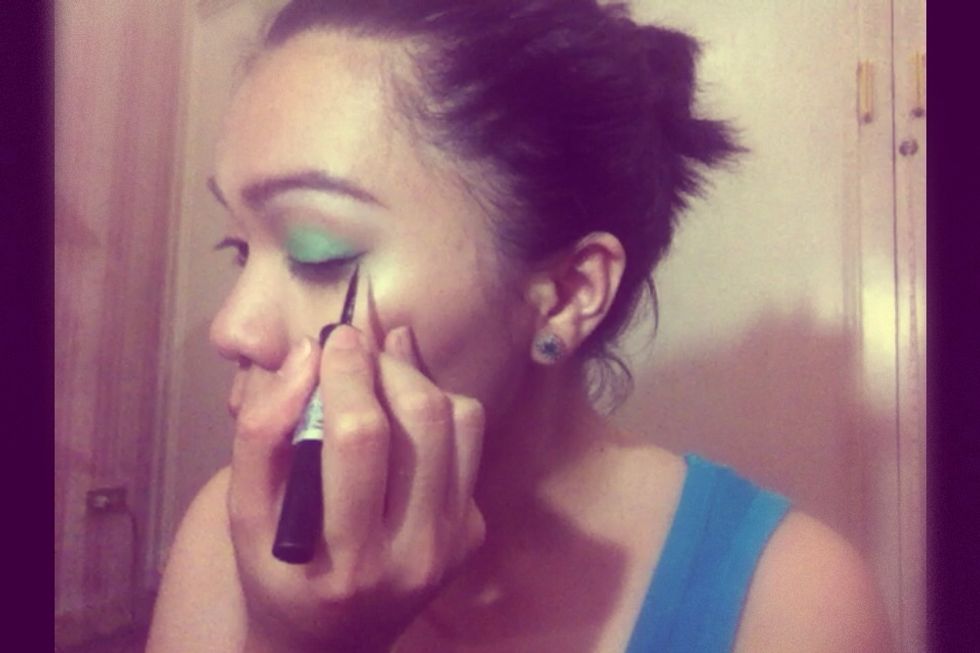 Line your eyes with a liquid liner in black. Make sure the ends are flicked and pointed. After which, from the inner corner of your eye going out create a line that will connect to the flick.