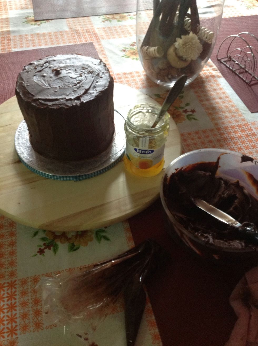 Lo cubrimos con ayuda de una esp\u00e1tula con la ganache sin dejar agujeros, esta capa ara de sujeta migas, lo refrigeramos 30 min y volvemos a dar una segunda capa y alisaremos bien las paredes.