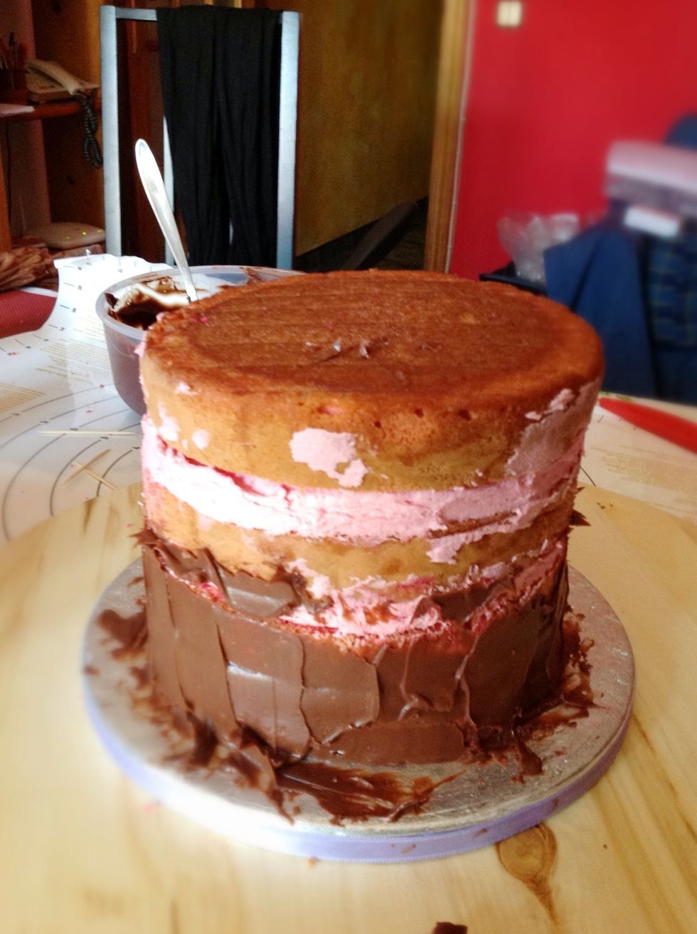 Lo montamos al rev\u00e9s para que la parte plana quede arriba, y los bajos los tapamos con ganache y tapamos m\u00e1s huecos si ha quedado alguno y alisamos.