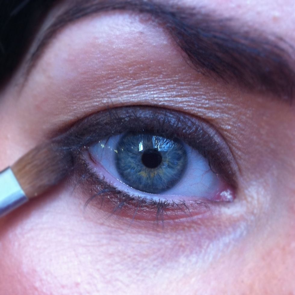 Load a flat eyeshadow brush with a brown eyeshadow and set the black eyeliner into place.