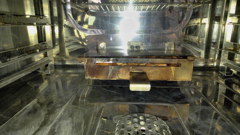 load the chip box into the oven, with the heating rod in the bottom slot in the back and hook the two eyes on the clips in back