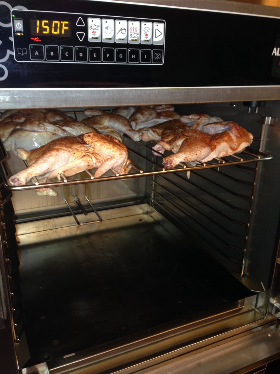 Load the racks of chicken into the oven, starting at the top slot and working your way down.