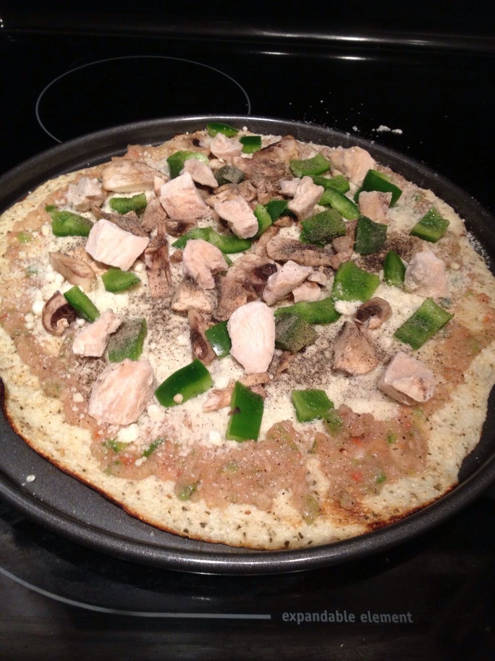 Load up your pizza with whatever you want. If you want what I used, add the sauce, then more onion, parmesan, cooked chicken, mushrooms, and green bell pepper and red pepper flakes.