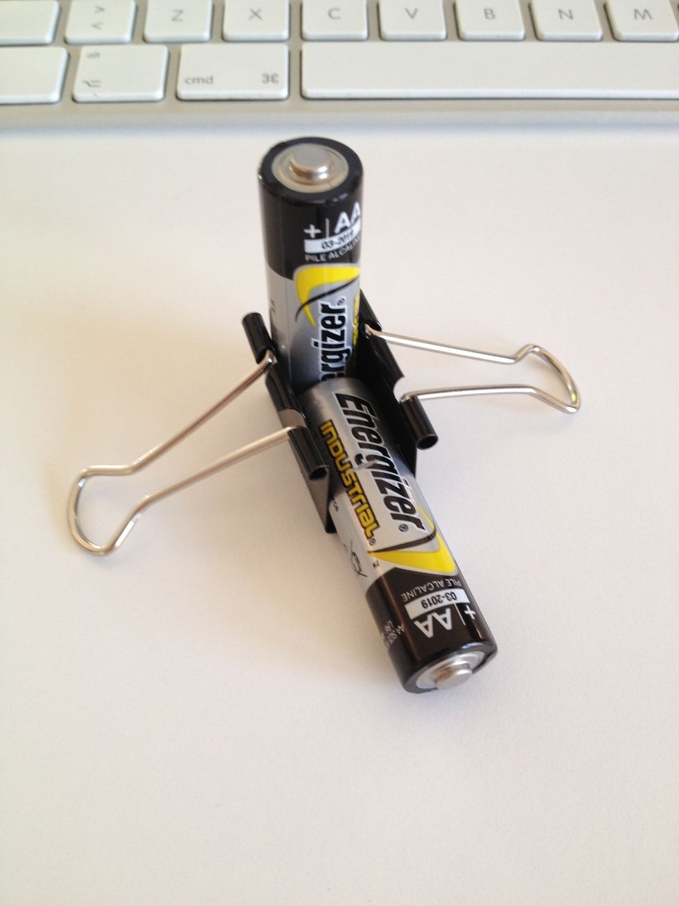 Locate the batteries one by one like shown on the image below. The standing battery should touch the clip's back.