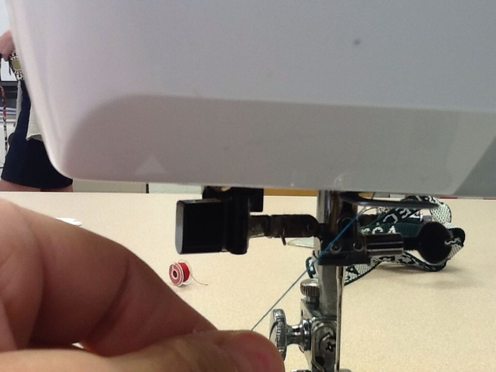 Locate the clip directly above the needle and slide the thread in.