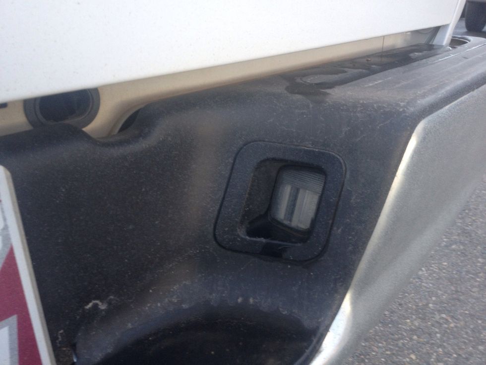 Locate the license plate on the back of the pickup and look to the left and right to find what bulb is burnt out and needs replaced.