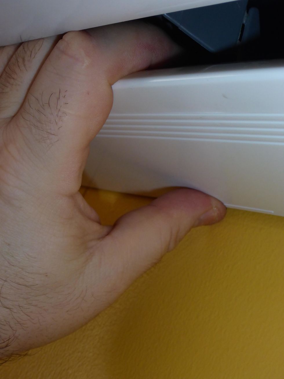 Locate the locking tabs. The location usually marked with a line or an arrow in the plastic. Push up, and pull towards you. Once all tabs are free, it will release.