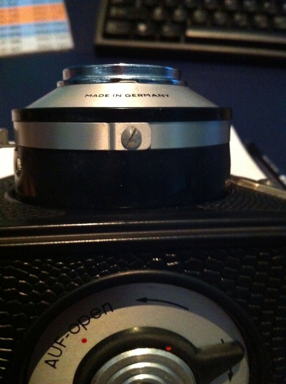 Locate the screw on the bottom of the ring on the lens housing and unscrew