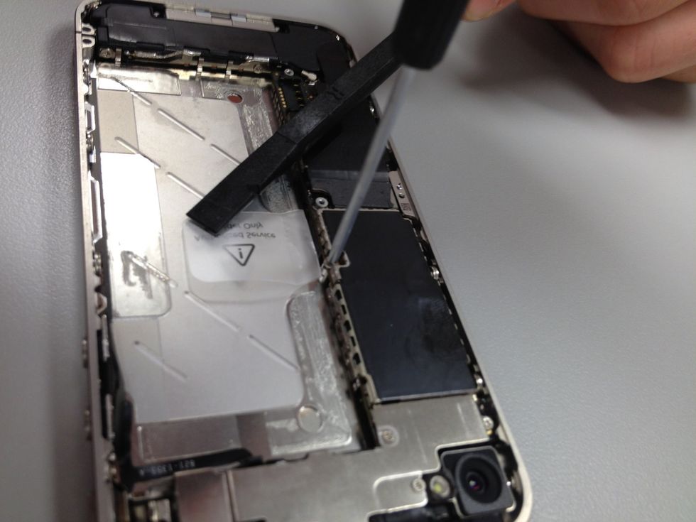 Locate the white sticker just to the left of the plastic pull tab that resided under the battery. Remove sticker and discover yet another tiny screw. 2.4 mm to be exact. Let's get that out of there.