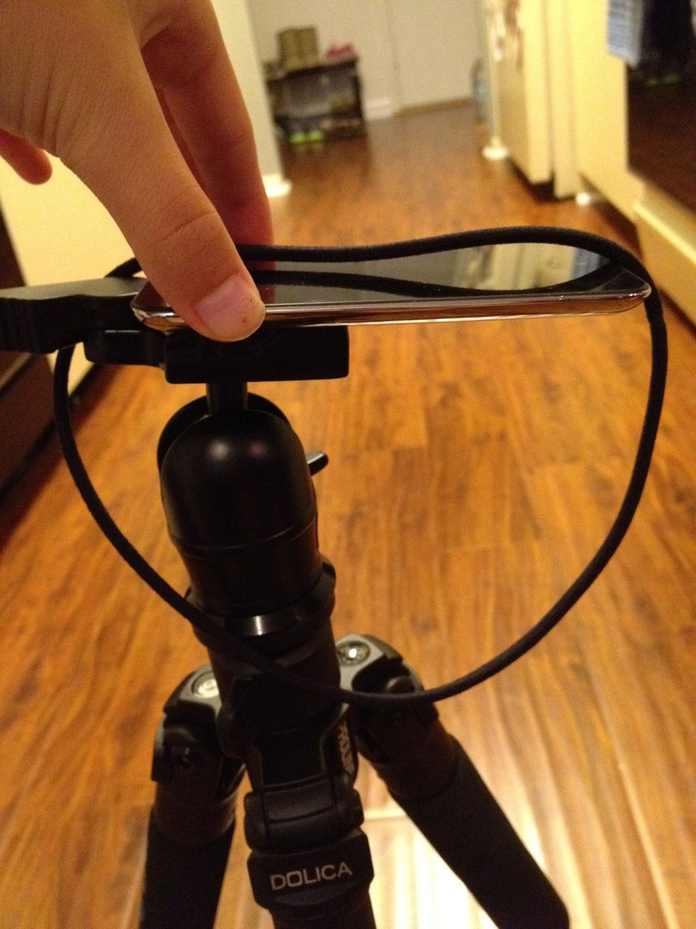 Loop around your device and the tripod.