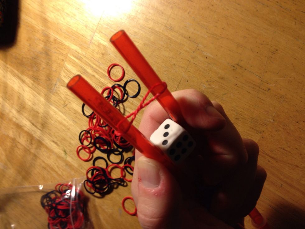 Loop band in figure eight between straws.