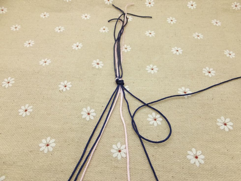 Loop it under and back through the opening. Pull up and to the left to tighten (remember to make two knots on each cord).