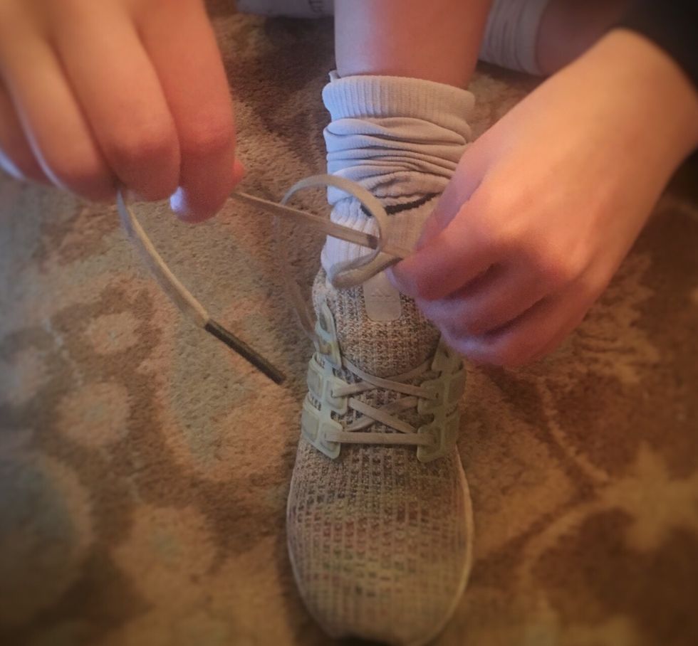 Loop one lace under the other.