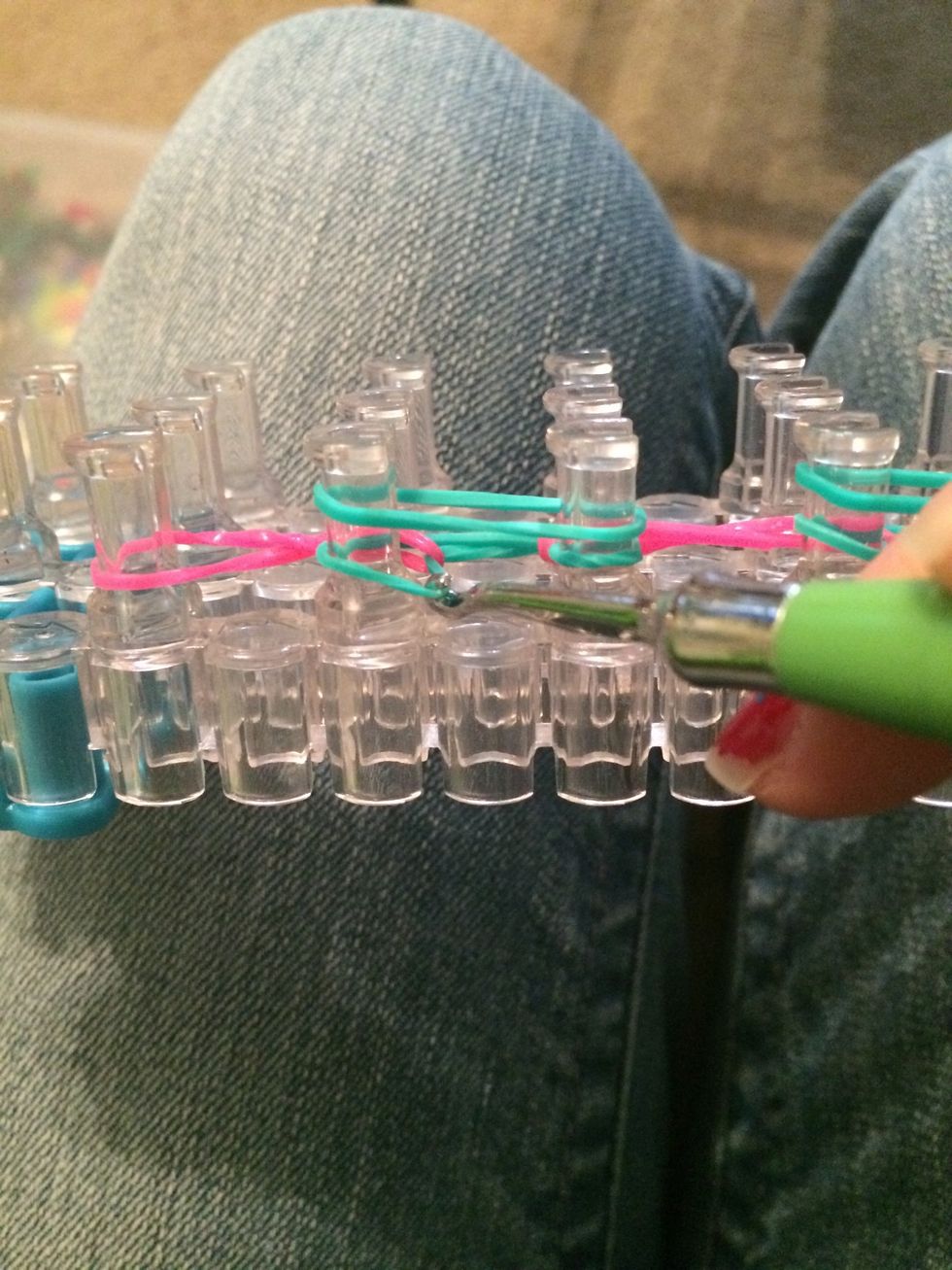 Loop over the bottom set of blue rubber bands