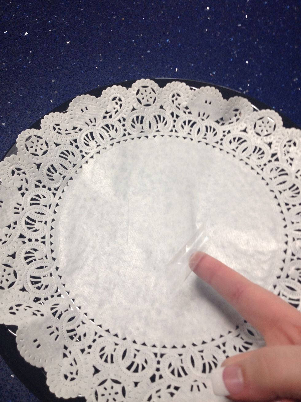 Loop some tape so it's sticky on all sides- place it underneath your doily on the platform of your container.