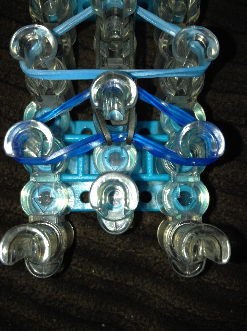 Loop the band to the peg in front of it.