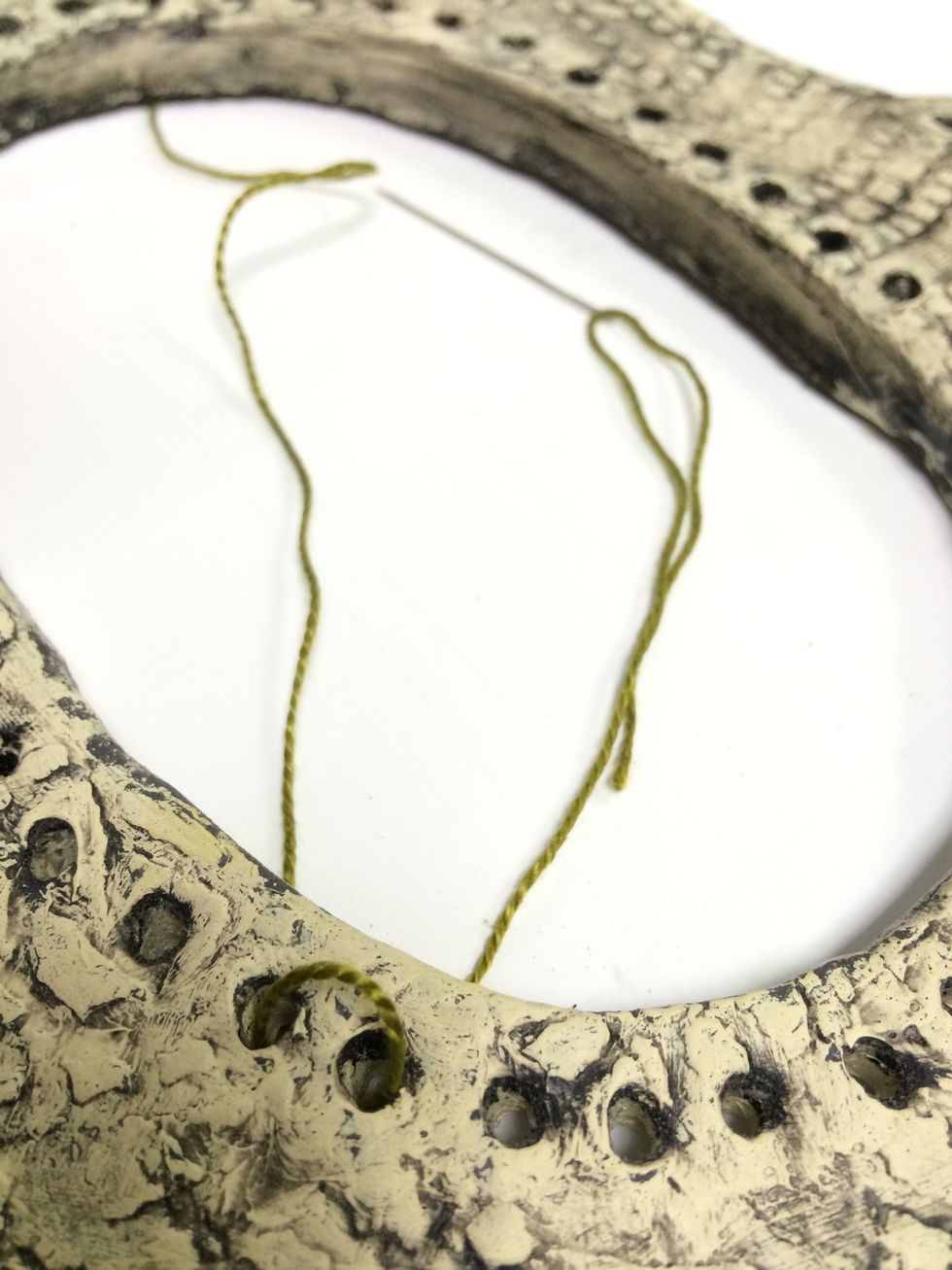 Loop the thread between any two holes.