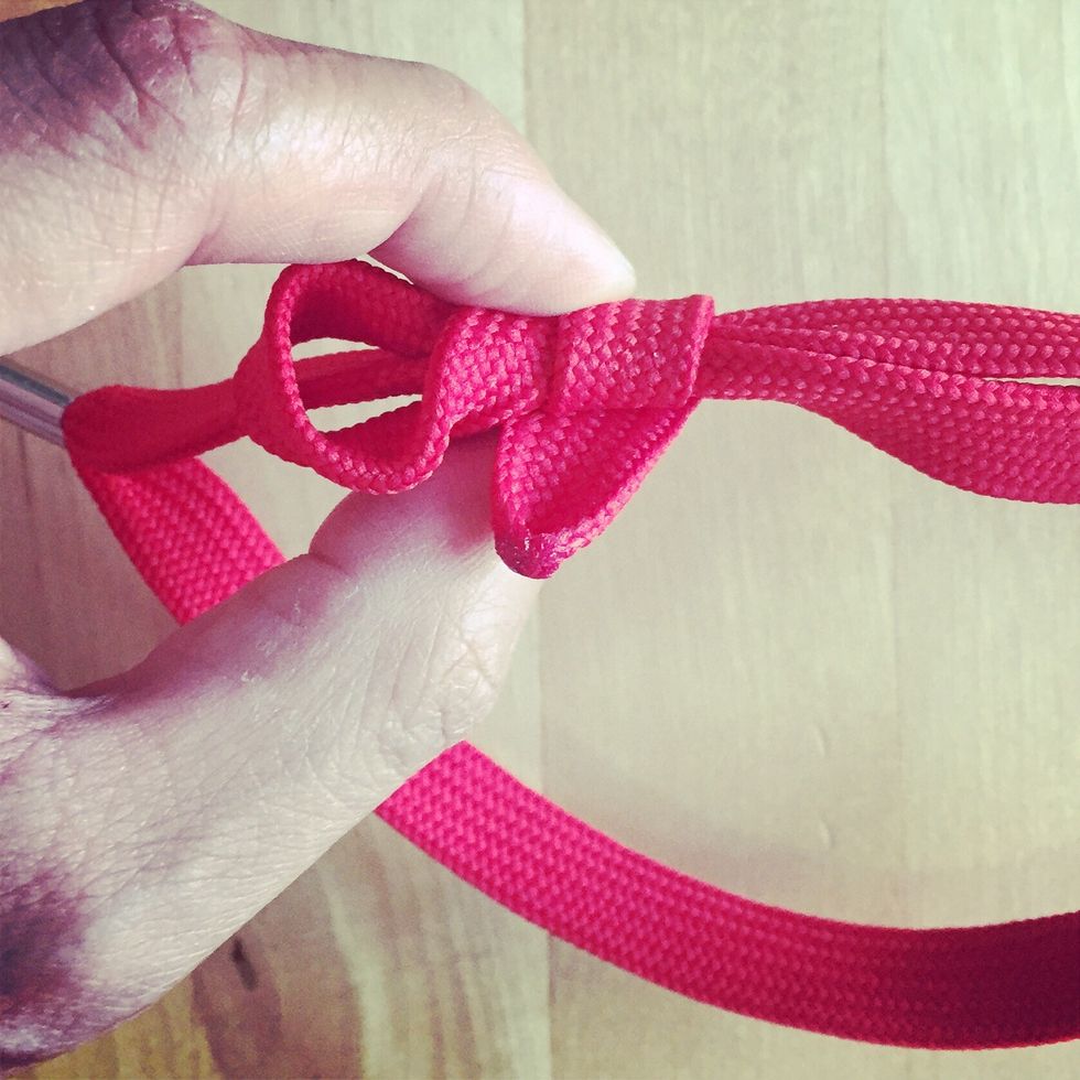 Loop the top strap upwards over and under twice.