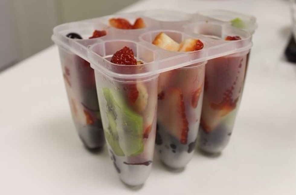 Loosely pack popcycle molds with sliced fruit and top with prepared green tea.