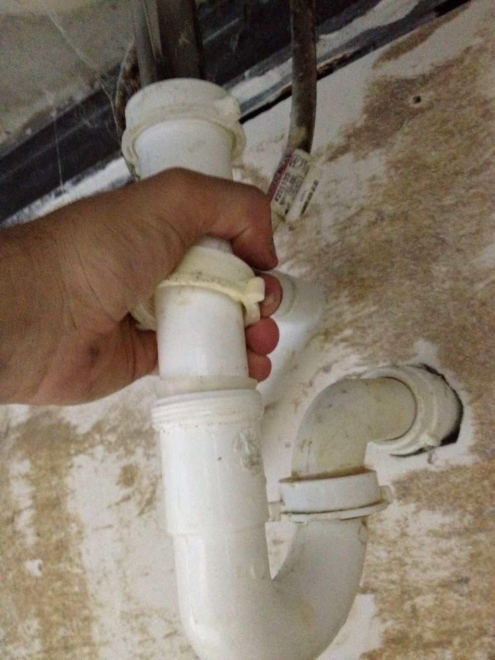 Loosen the fastener connecting the straight PVC pipe (above the trap) to the metal pipe (entering the bottom of the sink bowl). Grab the straight PVC piece and slide it up towards the metal pipe...