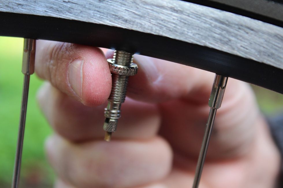Loosen the nut on the valve stem & place it to the side. (You might need to patch or change the tire if it has an big hole, but it's more likely that you're going to change the tube inside the tire.)