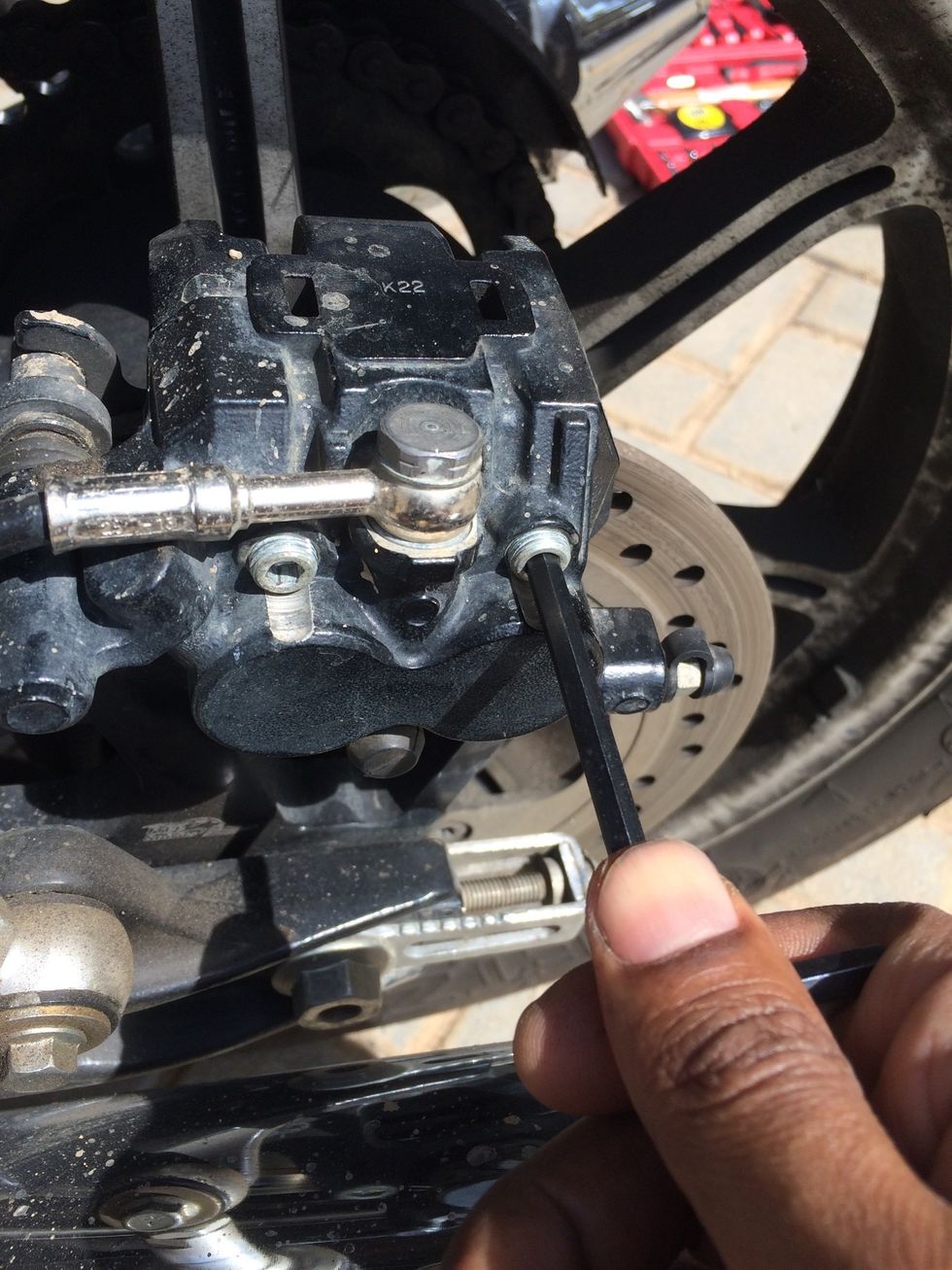 Loosen the pins but do not remove them yet