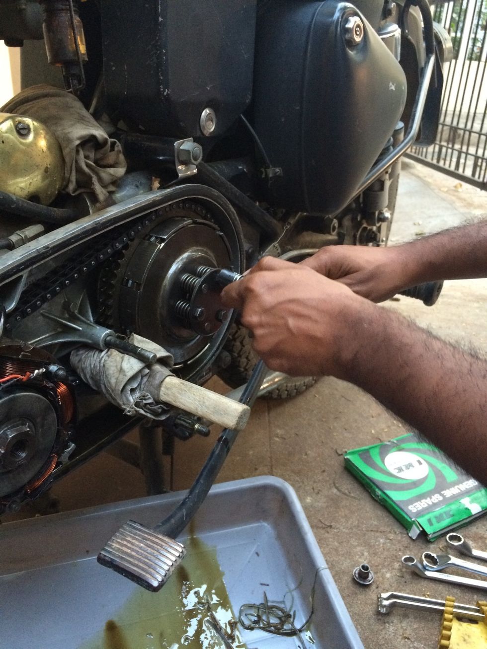 Loosen the three bolts alternatively. It is important not to undo one bolt at a time due to the spring tension