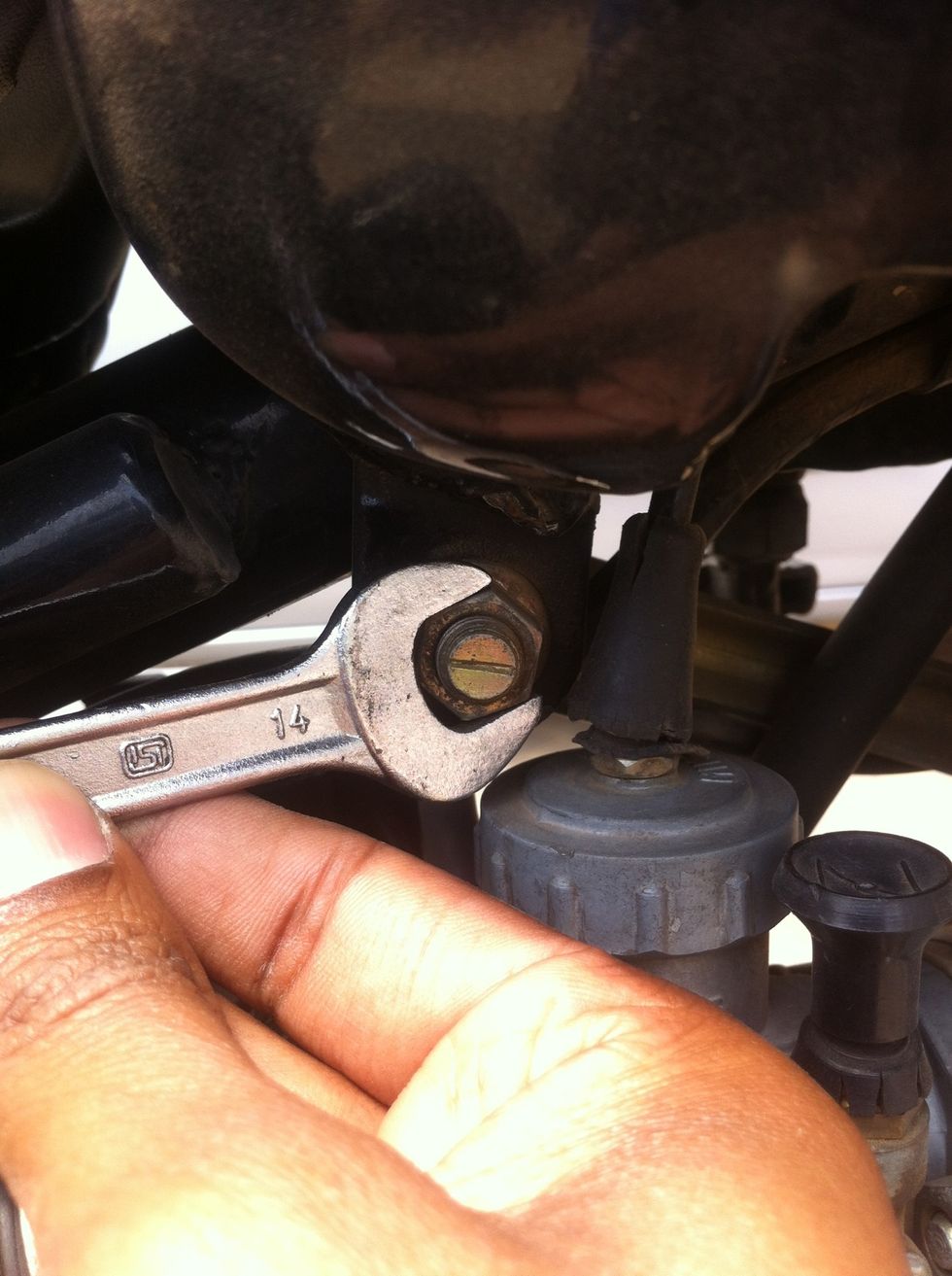 Loosening the rear nut with a 14mm spanner while holding the bolt with a same size spanner on the other side.