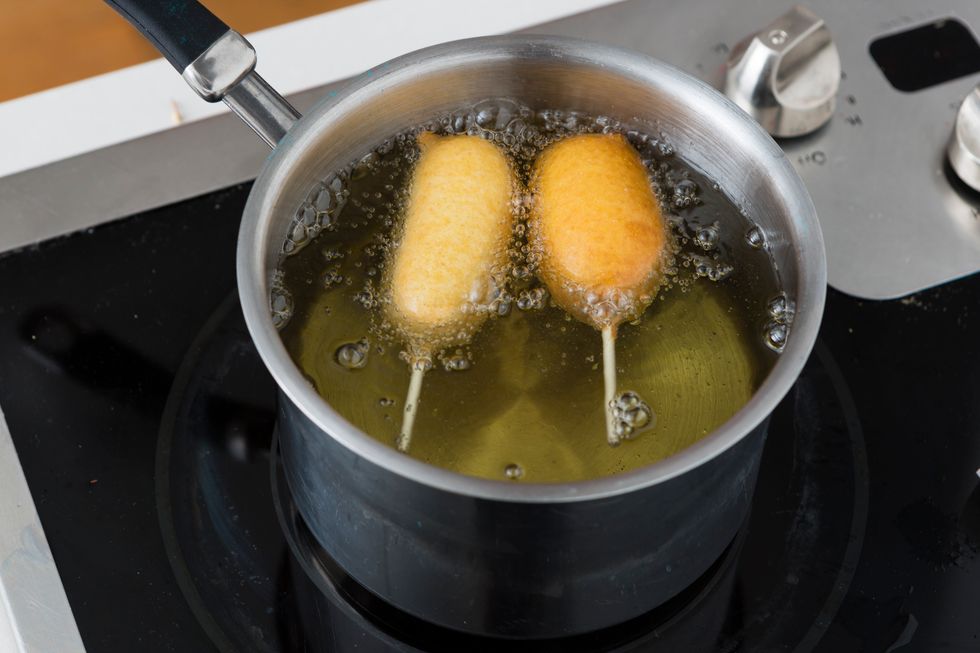 Lower each hot dog into the hot oil and fry until crispy, about 3 minutes.