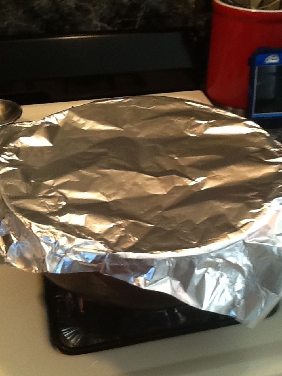 Lower the heat, take a piece of foil and place it on top of the pot.