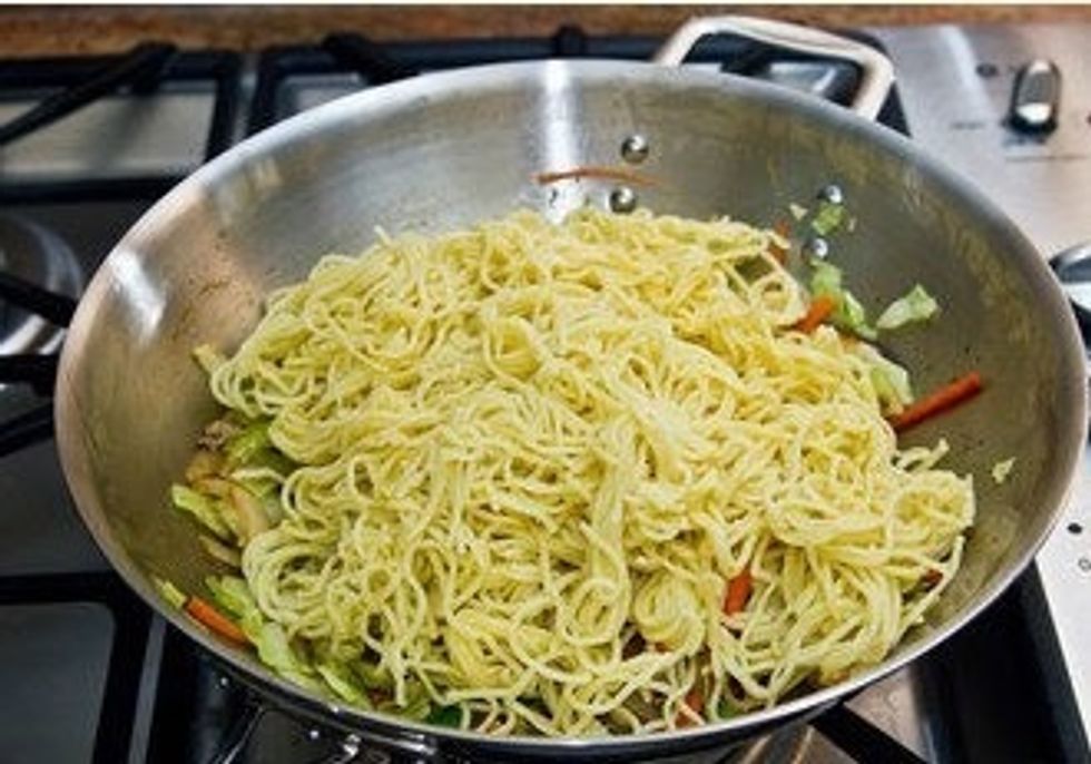 Lower the heat to medium. Add noodles, separating each other with hands. Keep stirring and make sure not to burn the bottom of the wok.