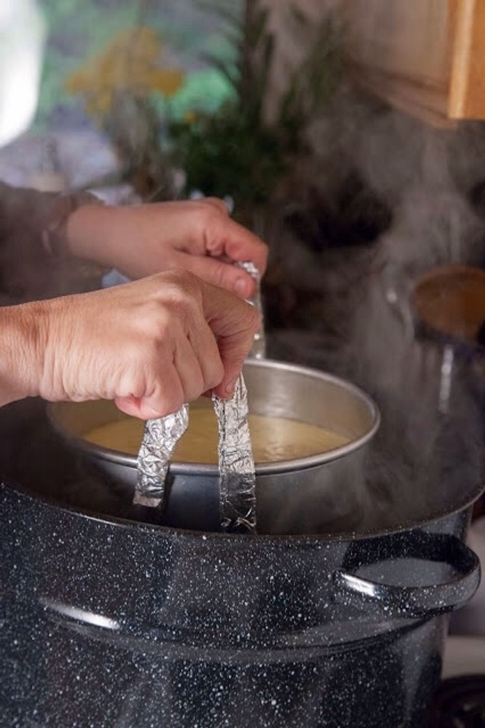 Lower the pan into the steaming pot.