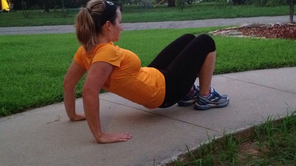 Lower your rear almost to the ground by bending your arms. We might as well get a little arm work here too!