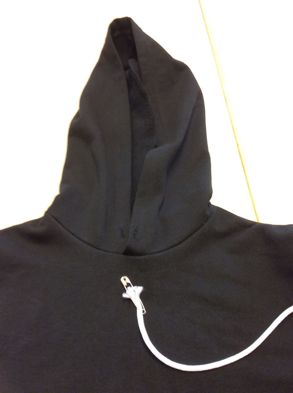 M\u00e4t och klipp av 120cm snodd till luvan. Anv\u00e4nd dig av en s\u00e4kerhetsn\u00e5l.