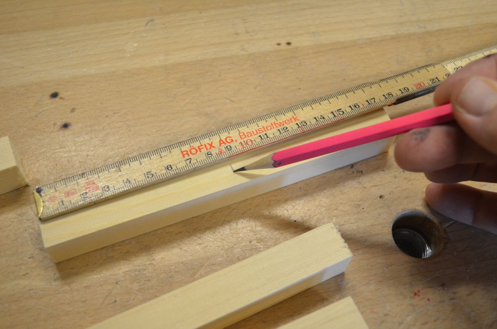 M\u00e4t ut och markera mitten p\u00e5 fyra av bitarna. Det bitar som skall vara grenar. En av de l\u00e4ngsta kan du v\u00e4nta med f\u00f6r den skall vara stammen p\u00e5 granen.