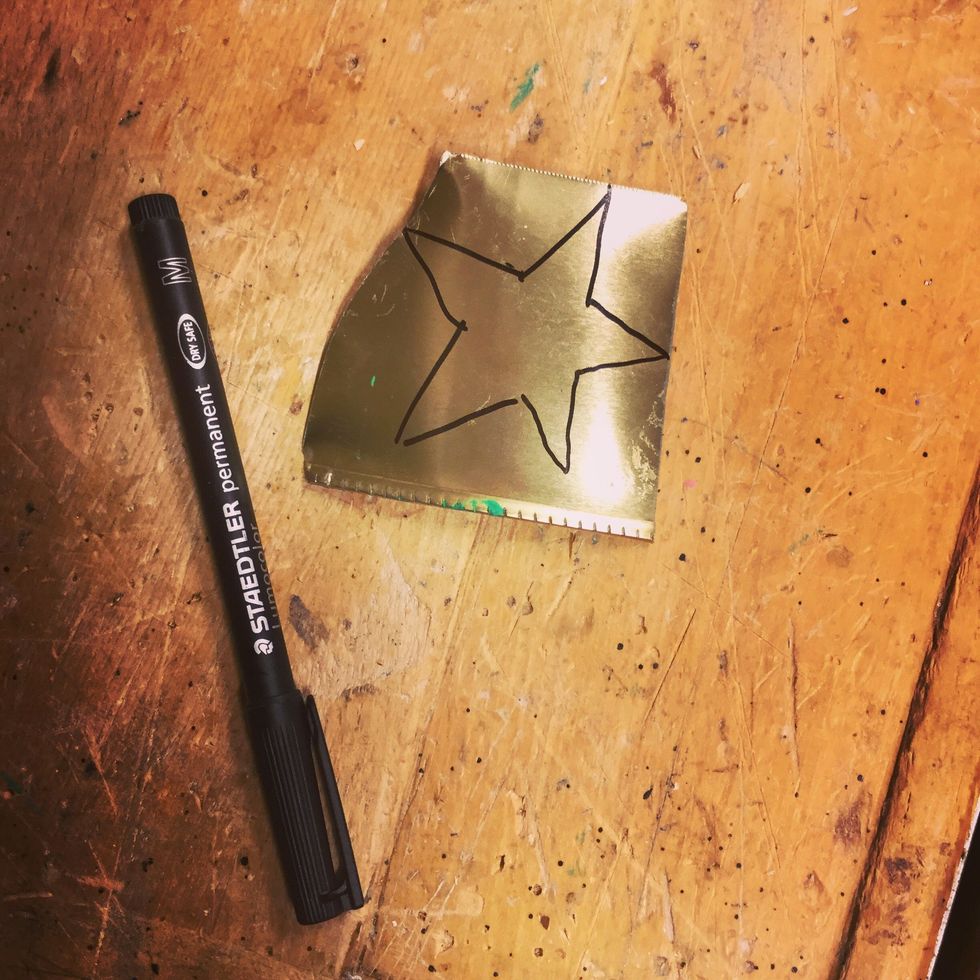 M\u00e5la en stj\u00e4rna med permanentpennan. Du ska klippa precis innanf\u00f6r linjen, t\u00e4nk p\u00e5 att f\u00e4rgen inte g\u00e5r bort.