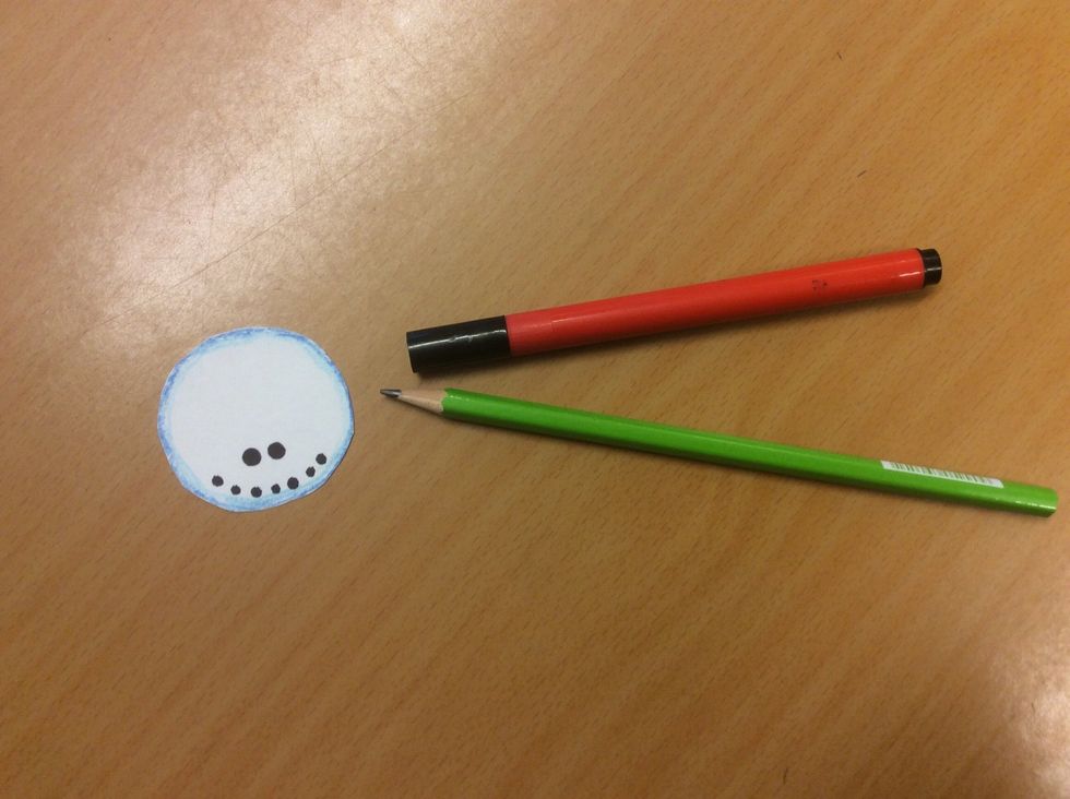 M\u00e5la \u00f6gon och mun, f\u00f6rst med blyertspenna och f\u00e5 ett godk\u00e4nt att det \u00e4r r\u00e4tt. Du ser ju sn\u00f6gubben uppifr\u00e5n, d\u00e4rf\u00f6r ska inte \u00f6gonen sitta mitt i ansiktet. Fyll sedan i med svart penna.