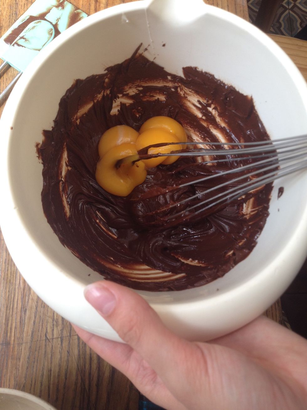 M\u00e9langez dans une terrine le m\u00e9lange chocolat-beurre refroidi avec les jaunes d'\u0153uf.