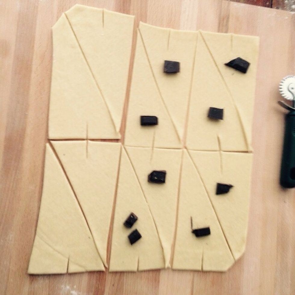 Make a 2cm cut on each short side of each triangle. Place a chunk of dark chocolate on each triangle. I like to leave some plain as well, up to you.