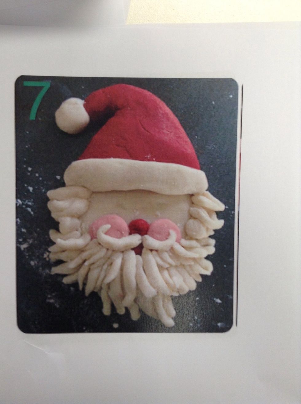 Make a beard by rolling small sausage shaped pieces of Doug between your fingers and layering up. Start along the outside edge and work upwards. Lastly make a curled end moustache!