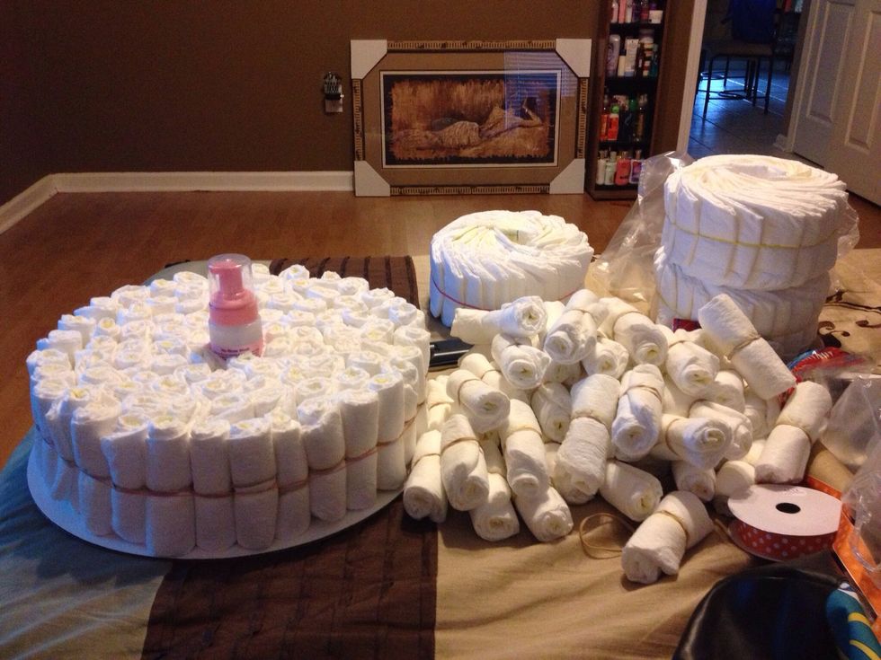 Make a circle of diapers start with one diaper in the middle and join diapers around that one diaper. Then rubber band that bundle and add more diapers around your first bunch. Repeat til desired size