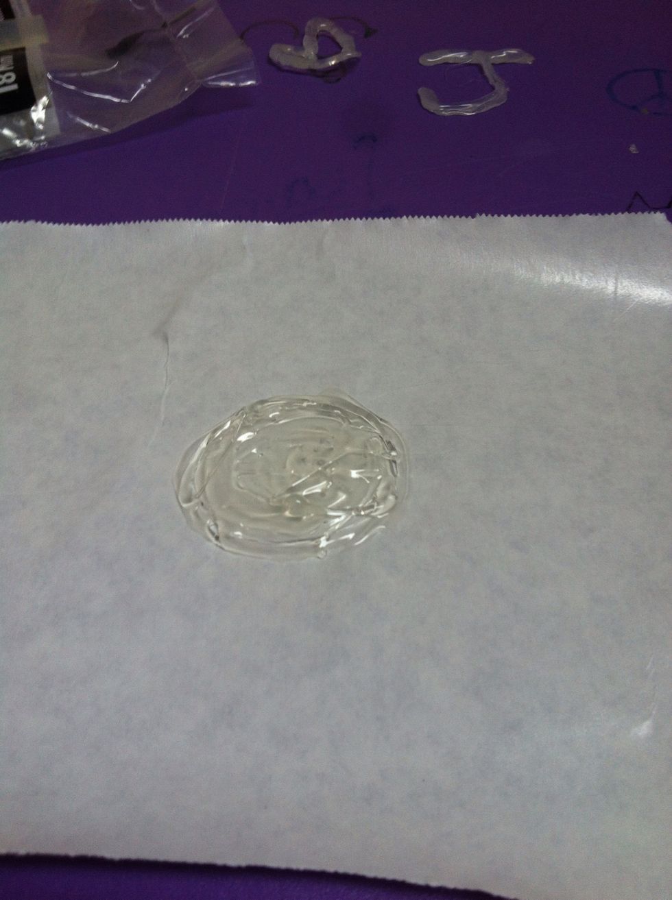 Make a circleish shape made of glue. Keep it loose and messy, since it will give a more realistic melting appearance. Make sure this is on the waxy side of the freezer paper.