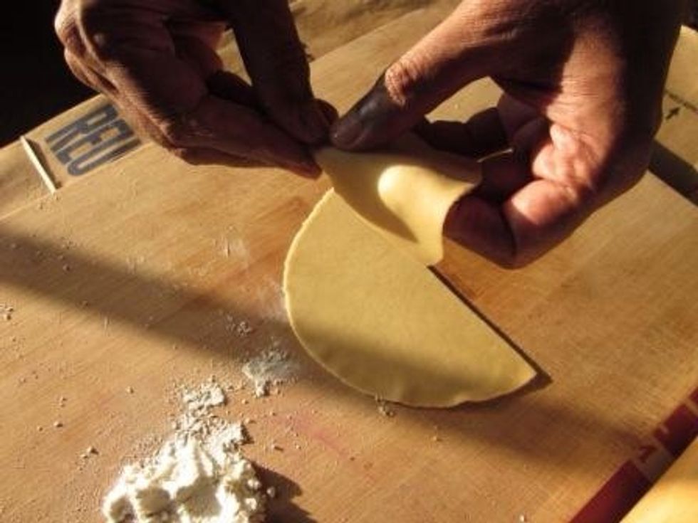 Make a cone out of the half piece of dough with a seam that overlaps about 1/4 inch. Seal the seam together with water. Also press the edges together just to make sure that your seam comes together.