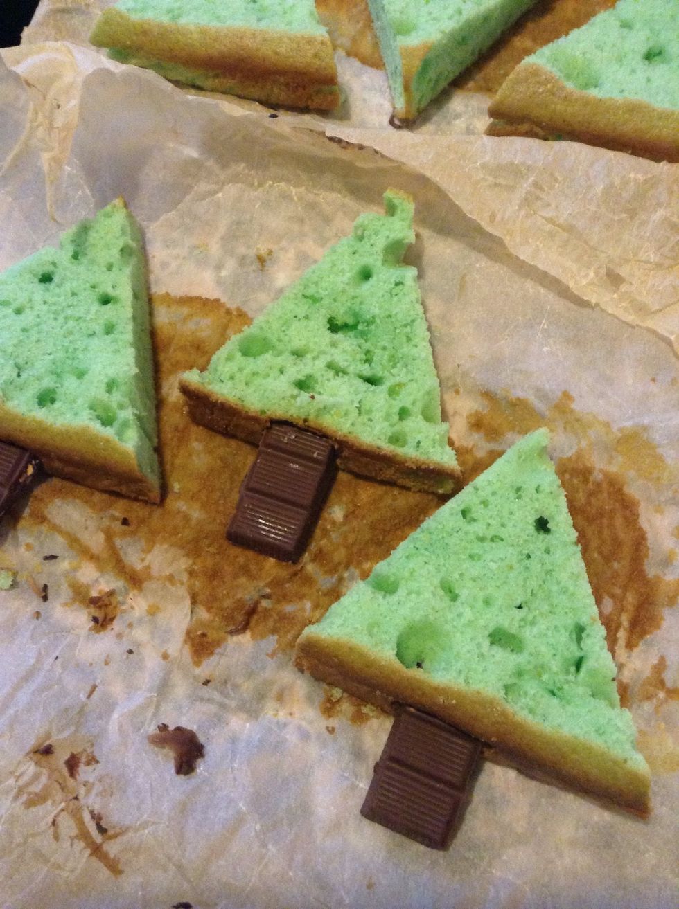 Make a cut into the basis of your triangles and thread a piece of chocolate bar as trunk of your christmas trees.