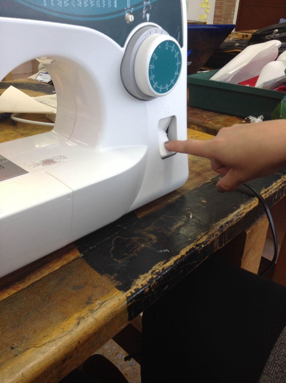 Make a first straight stitch and then press the BACK stitch button for another stitch. This will help you hold the thread acting as "a knot".