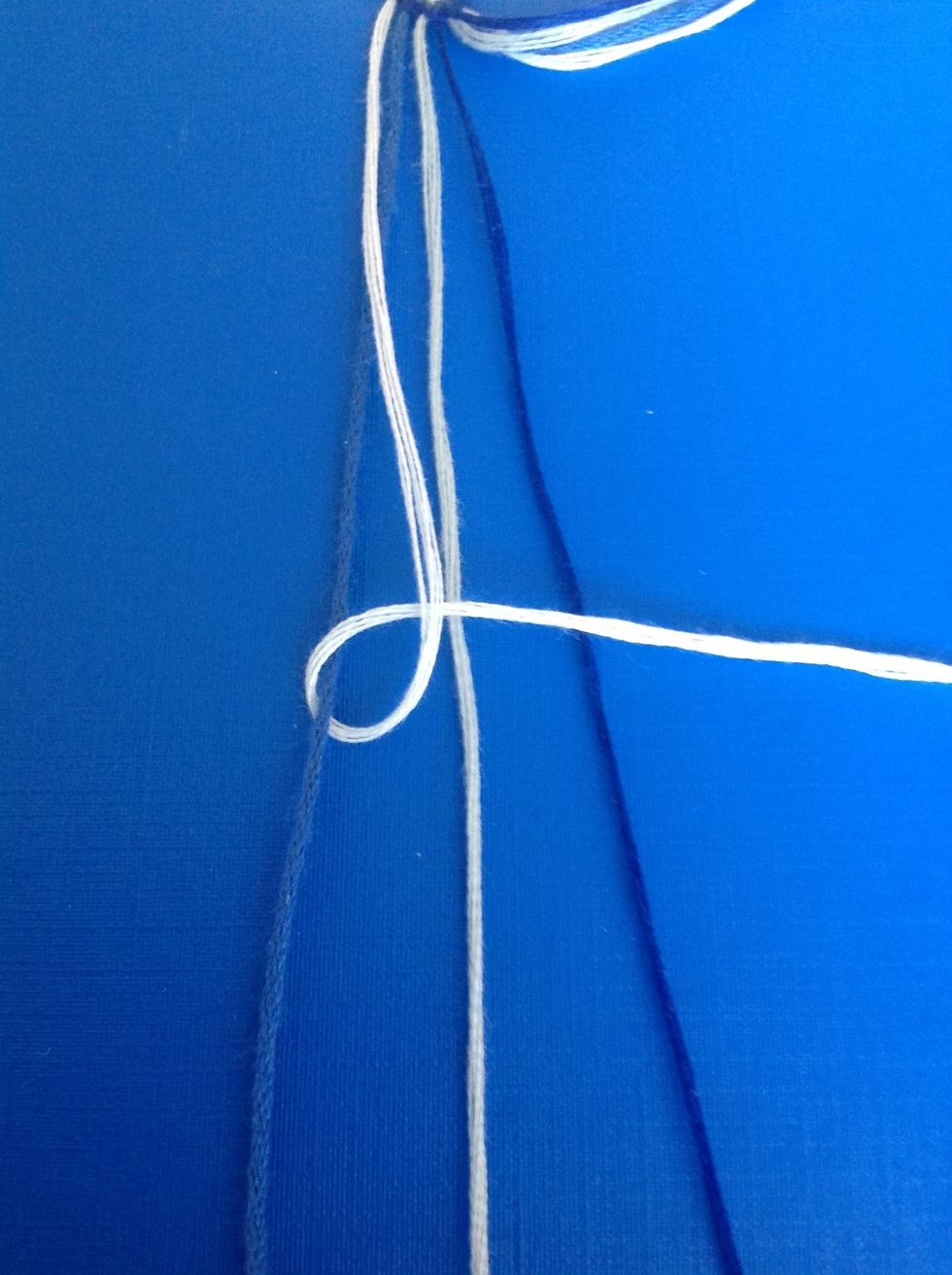 Make a forward knot over the first string. Do this twice to make one knot