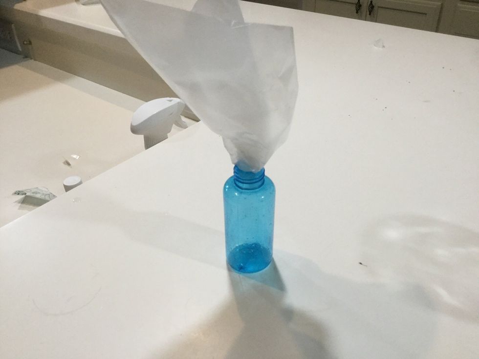 make a funnel by rolling up wax paper and trimming the bottom (or use a normal funnel if you have one)