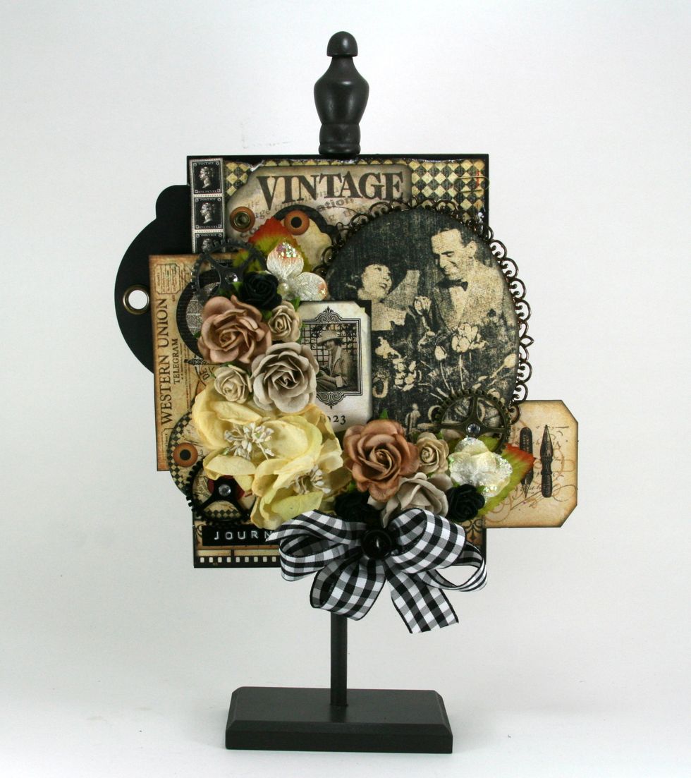 Make a generous loopy bow of Black Plaid Ribbon from Really Reasonable Ribbon and adhere to stand then finish off with small black button.